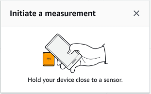 Mão segurando um dispositivo próximo ao ícone de um sensor, ilustrando o início da medição de proximidade.