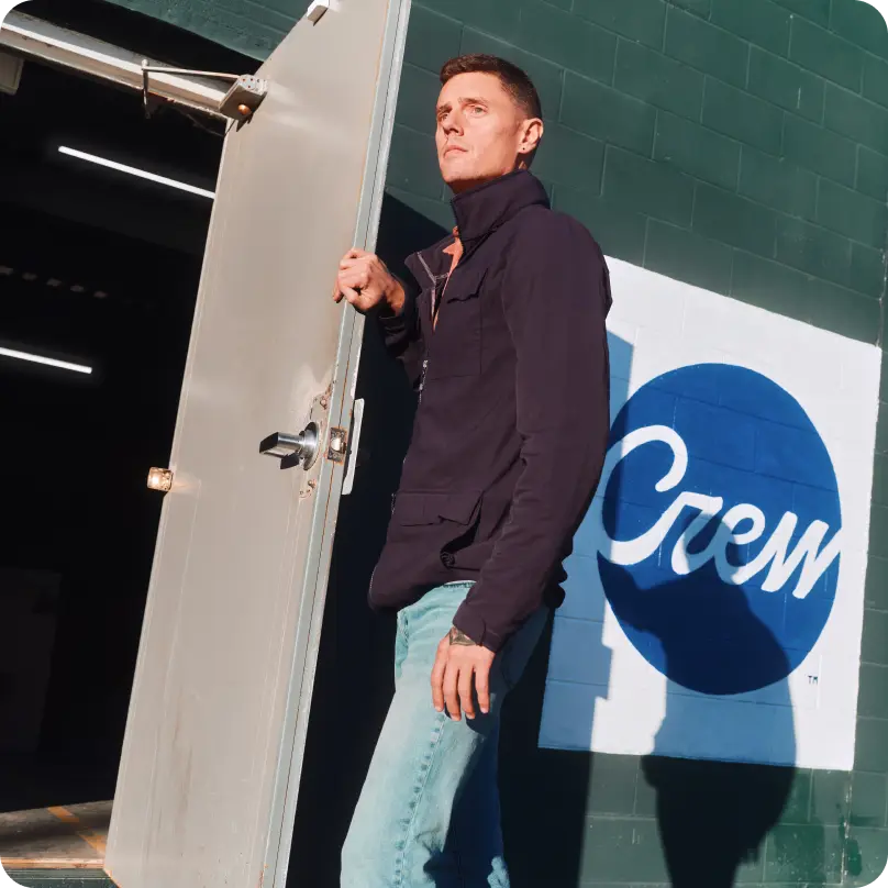 Marshall Sterling stepping through an open metal door of the Crew Supply Co. building.