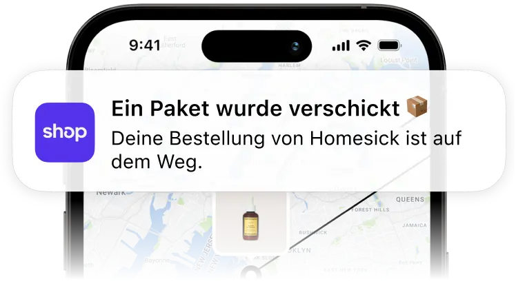 Ein Mobiltelefon, das eine Benachrichtigung der Shop-App anzeigt, dass ein Paket von Homesick versendet wurde, mit einer Tracking-Karte im Hintergrund