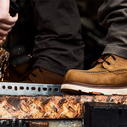 close up of person wearing workboots using an angle grinder