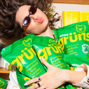 girl in sunglasses hugging multiple green bags of gruns