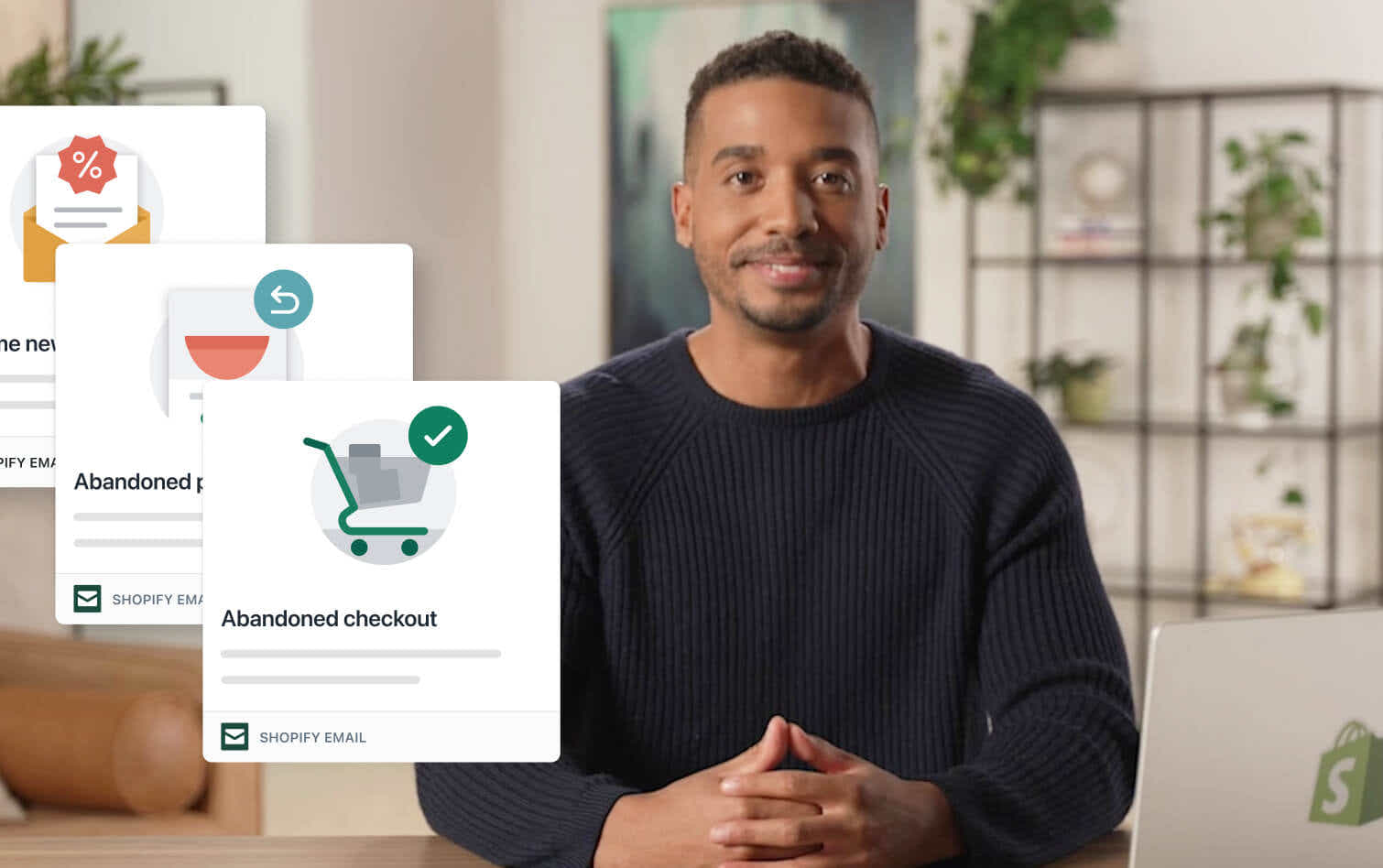A man in a navy blue, long sleeve sweater sits at a table with a laptop and describes how new re-engagement marketing automations work. A module appears beside him with an illustrated product page and the words “abandoned product browse” on it. Another module has an illustrated shopping cart and the words “abandoned checkout” on it. A third module has an illustration of an open letter and percentage symbol on it.